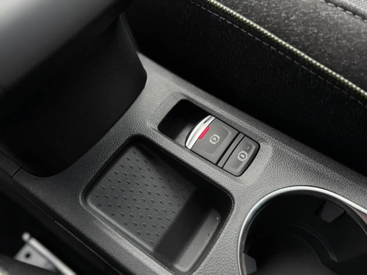 Gros plan sur la console centrale noire du Renault Captur 2026, avec frein de parking électrique et rangement.