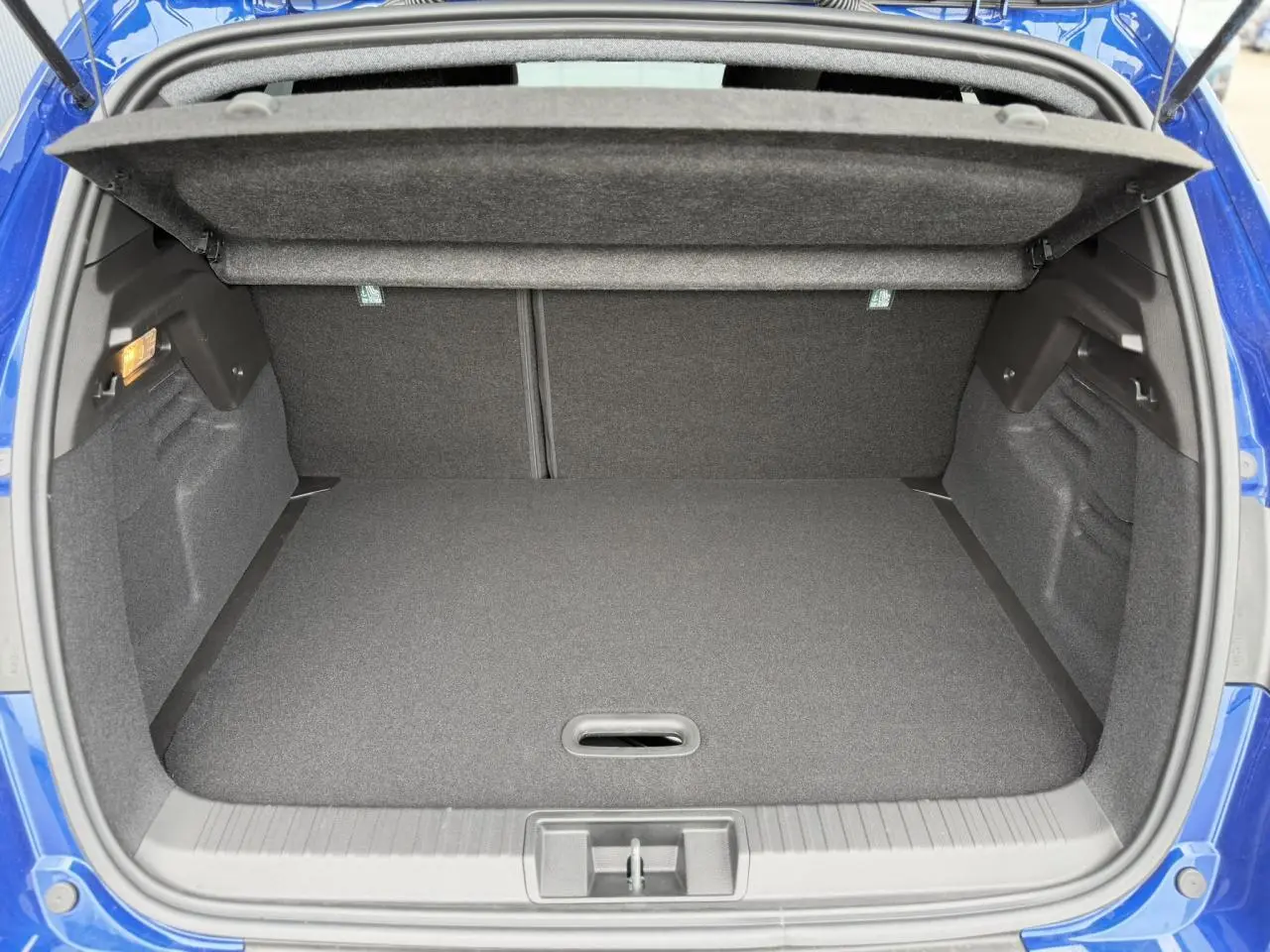 Coffre ouvert vu de l'arrière d'un Renault Captur 2026 Bleu Iron, montrant l'espace de chargement vide.