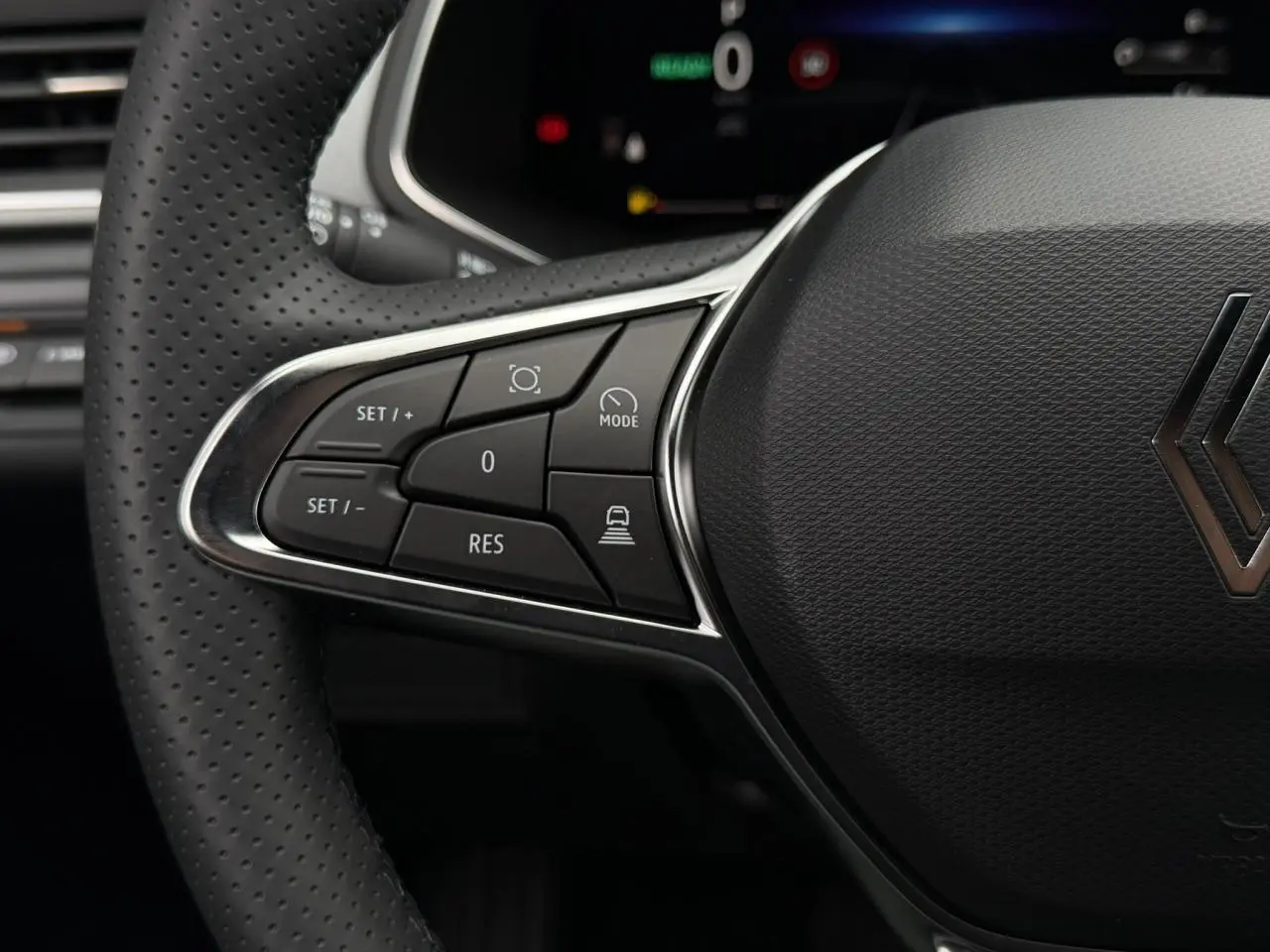 Gros plan sur le volant en textile noir du Renault Captur 2026, avec commandes intégrées côté gauche.