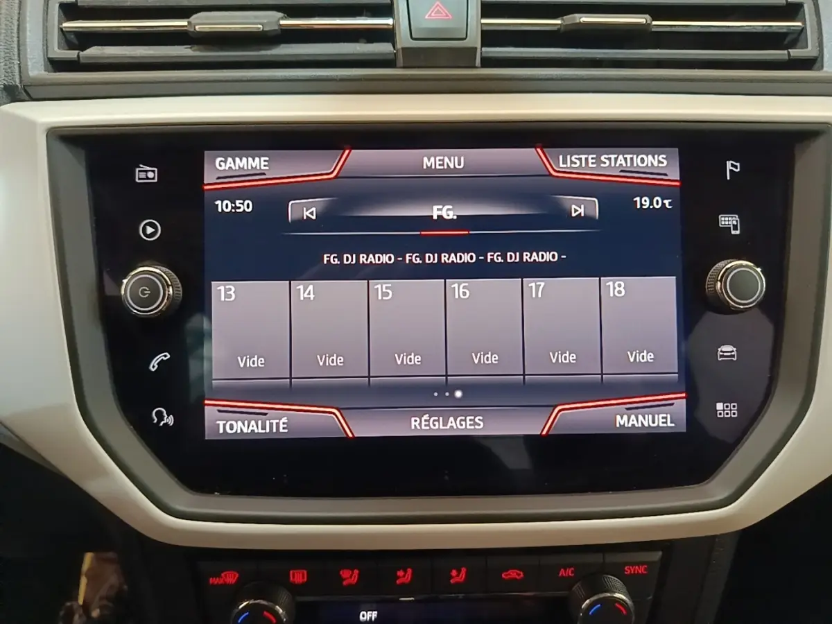 Écran tactile central du tableau de bord du SEAT Arona 2019 affichant les stations radio, vu de face.