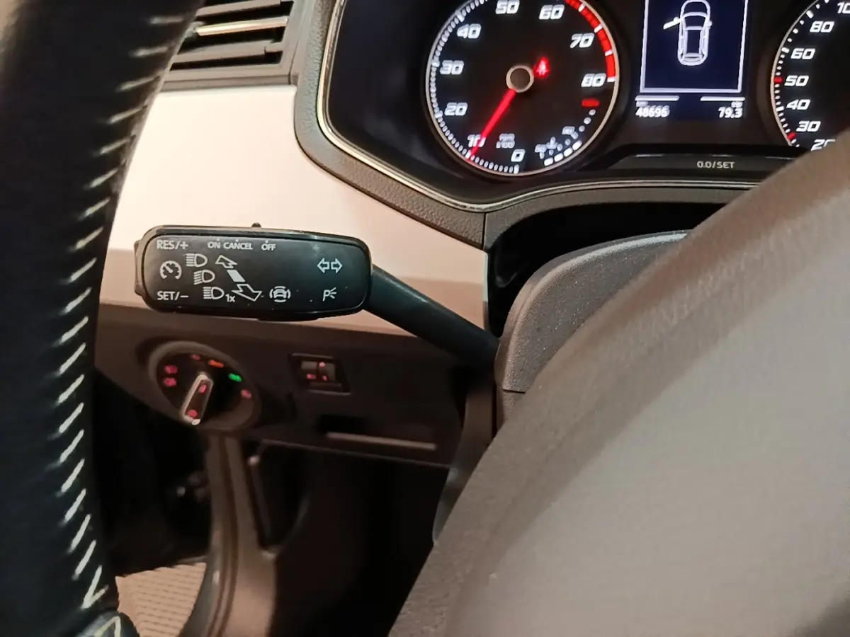 Gros plan sur le commodo gauche du volant d’une SEAT Arona 2019, tableau de bord avec compteurs et affichage digital.