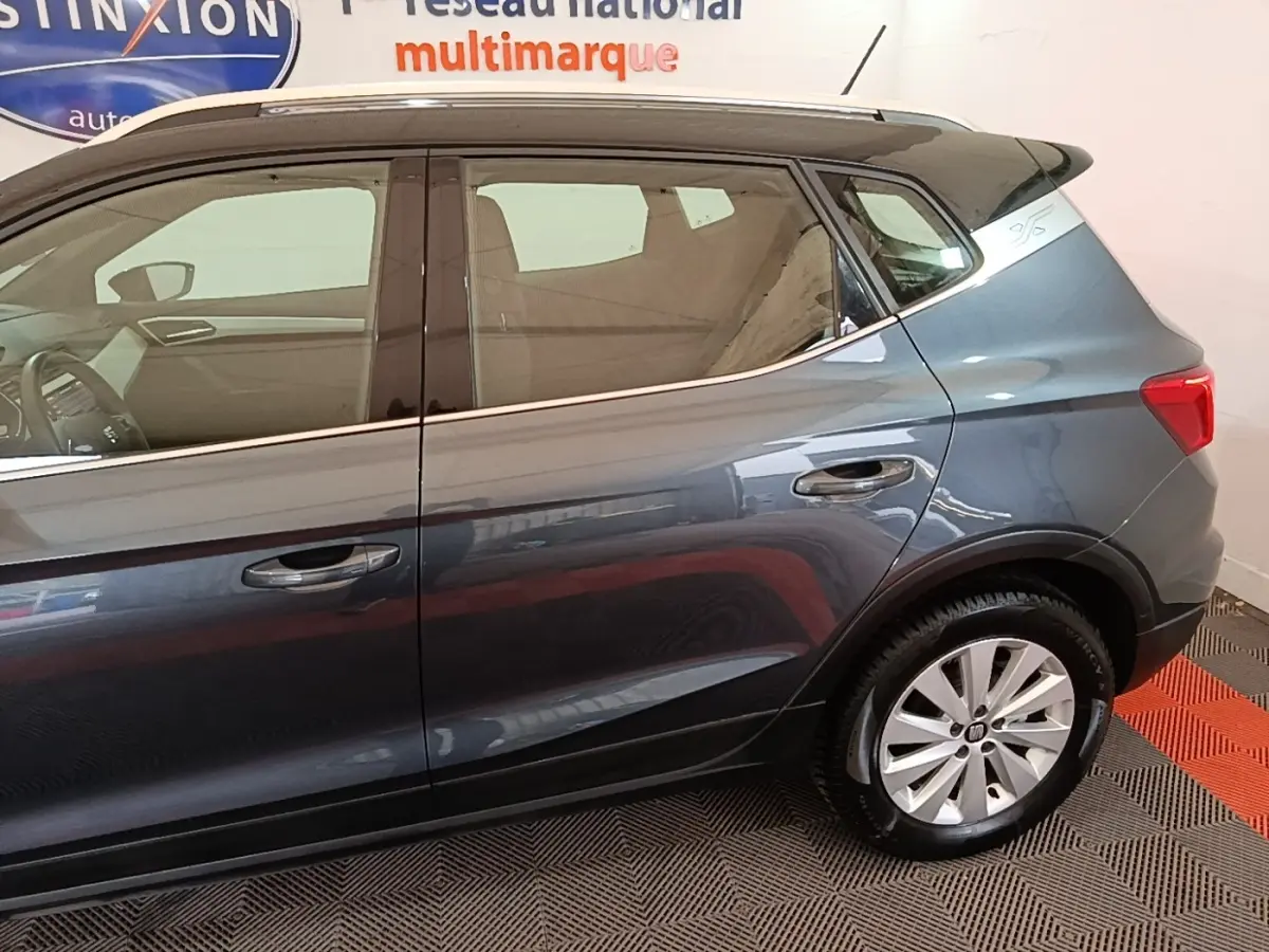 Vue latérale droite du SEAT Arona gris clair, mettant en valeur les jantes alliage et les lignes de la carrosserie.
