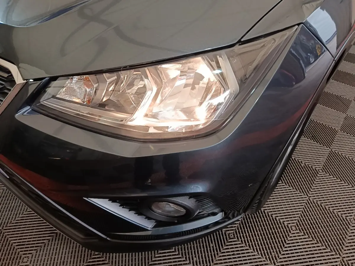 Gros plan sur le phare avant droit et le pare-chocs gris foncé d'un SEAT Arona 2019, avec antibrouillard intégré.