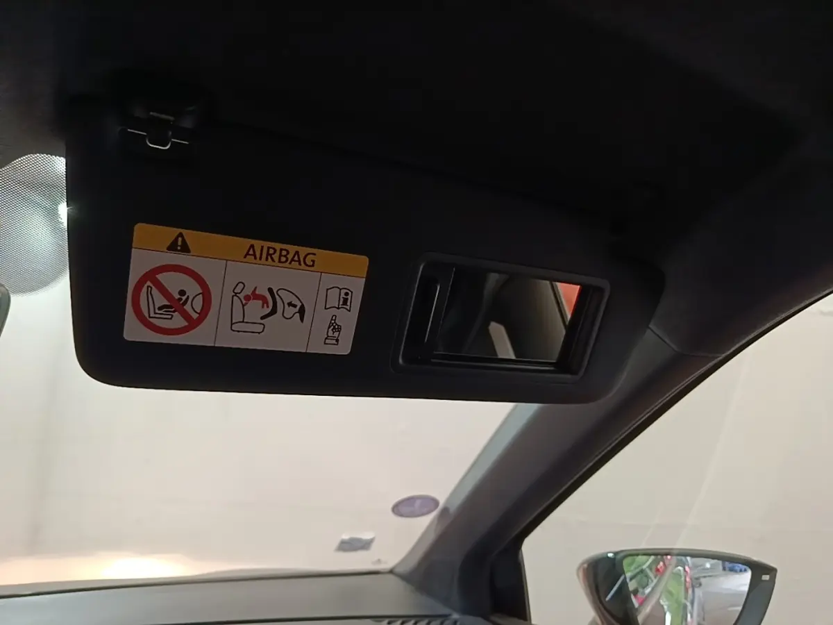 Détail de pare-soleil avec miroir et avertissement airbag à l'intérieur d'un SEAT Arona 2019, côté conducteur.