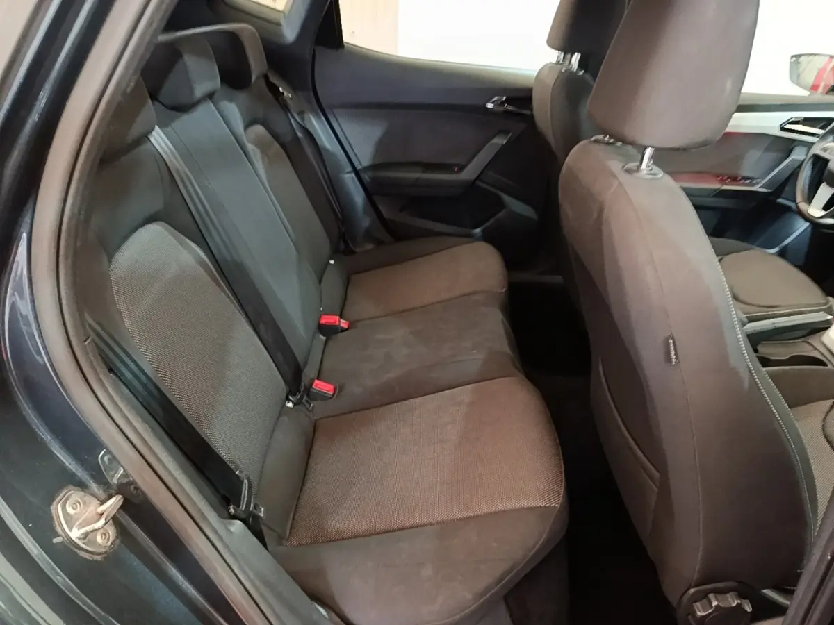 Vue intérieure côté gauche montrant la banquette arrière et les sièges avant gris foncé du SEAT Arona 2019.