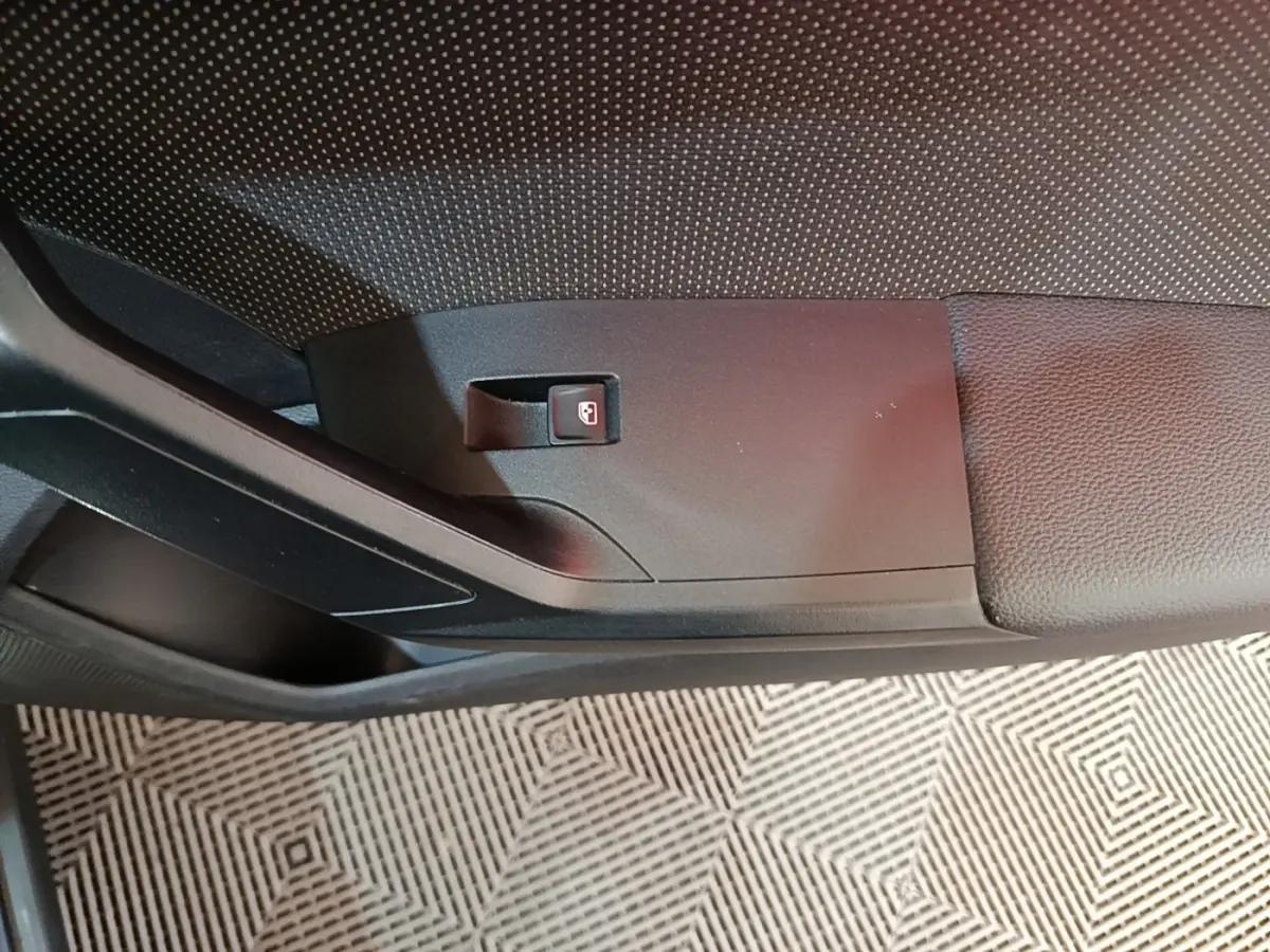 Détail de la poignée intérieure de porte côté conducteur du SEAT Arona gris clair, avec bouton de verrouillage.