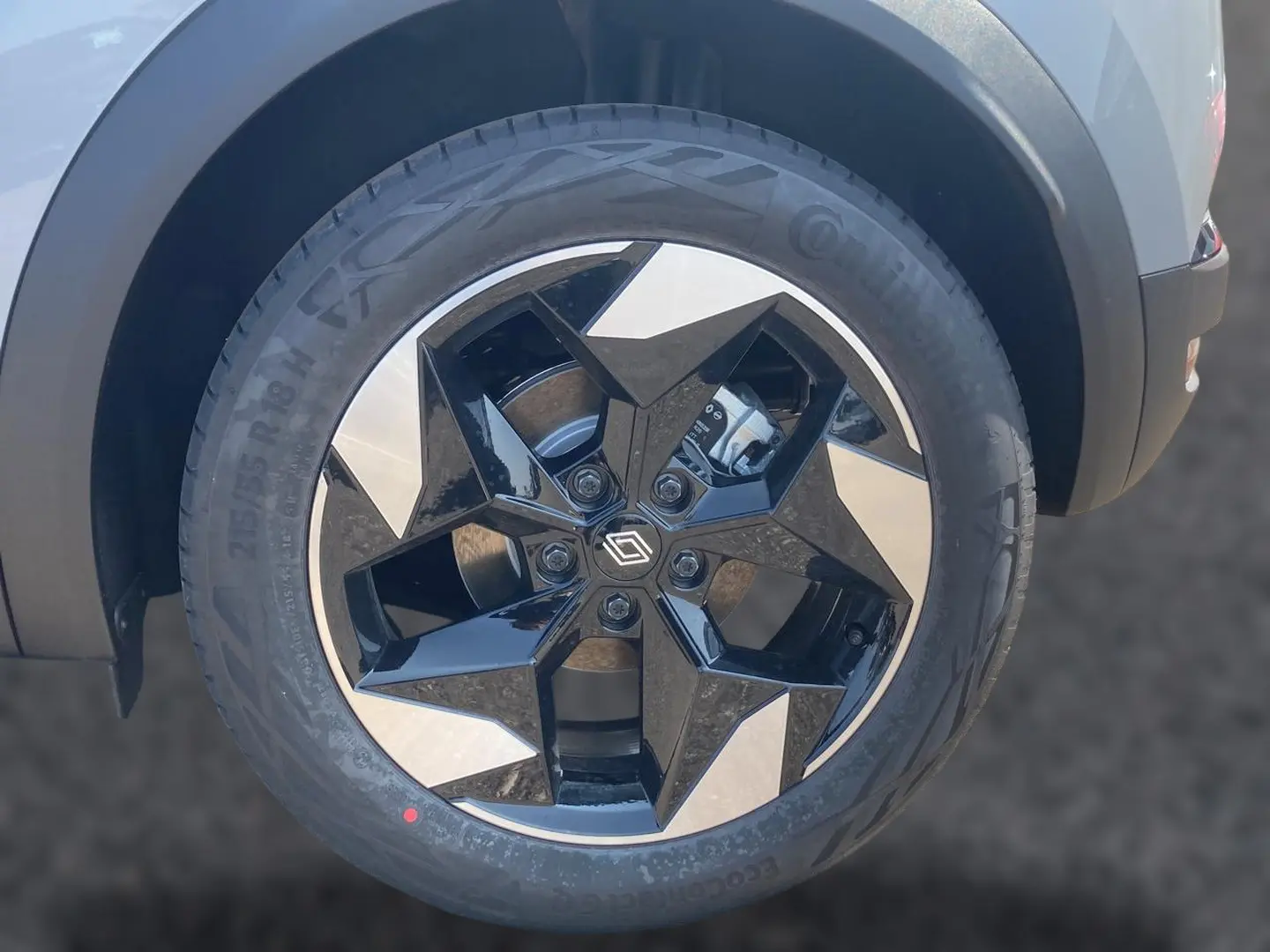 Gros plan sur la roue avant droite du Renault Captur 2026 Rafale avec jante alu noire et argentée au design géométrique.
