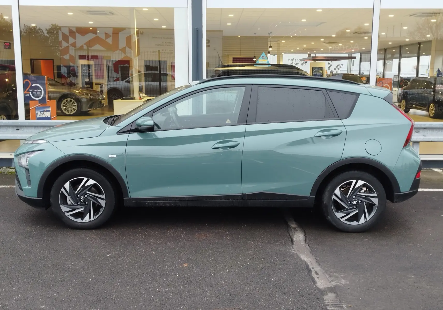 Vue de profil côté gauche d'une Hyundai Bayon 2022 hybride en couleur Elemental Brass Metal, avec jantes alliage distinctives.