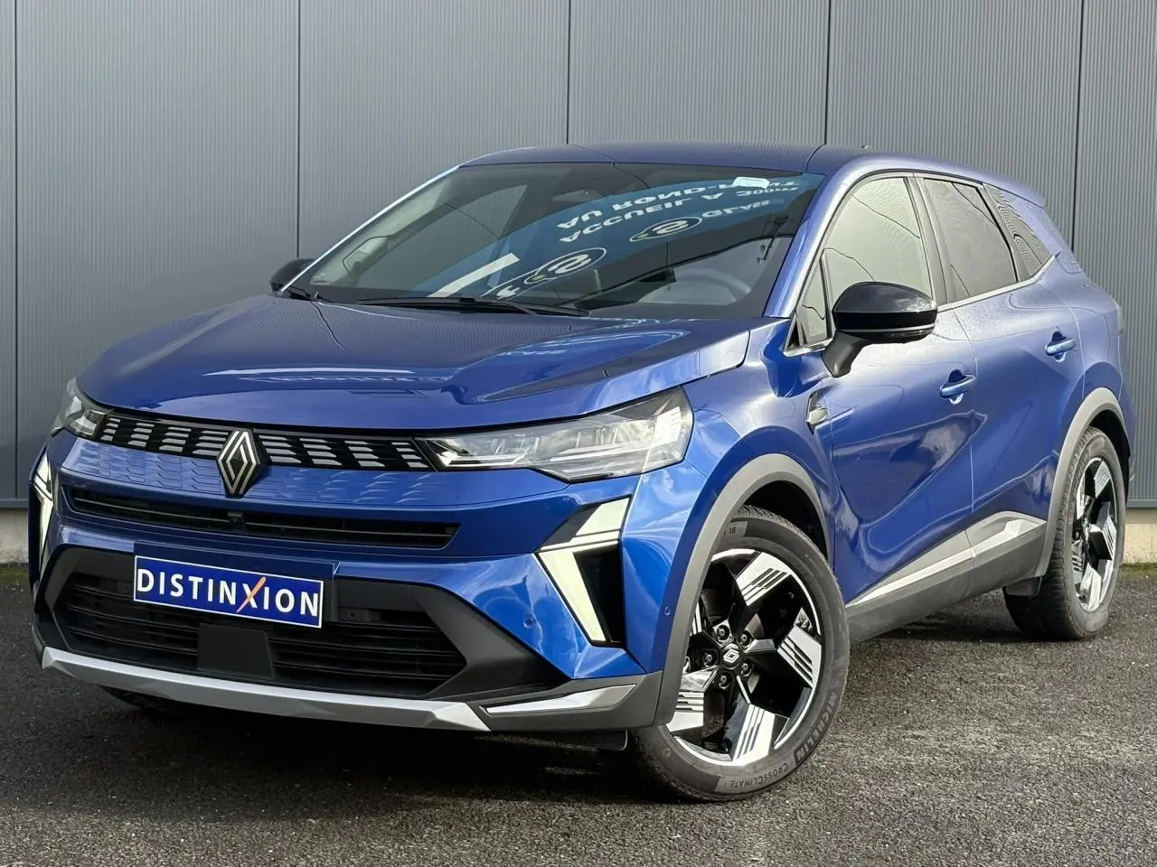 Renault Symbioz bleu Iron en 3/4 avant droit, avec jantes 18 pouces et calandre distinctive noire.