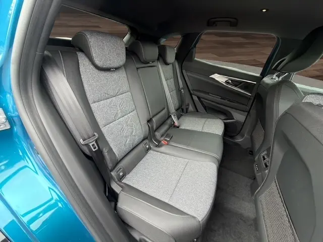 Vue intérieure arrière côté droit du Renault Austral bleu, montrant la banquette trois places en tissu gris et cuir noir.
