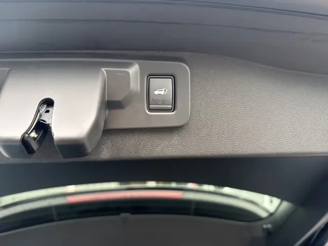 Bouton d'ouverture motorisée du hayon sur le bord intérieur du coffre du Renault Austral bleu 2026.