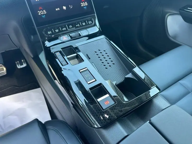 Vue rapprochée de la console centrale noire brillante du Citroën C5 Aircross 1.2 Hybride avec commandes tactiles et rangement intégré.