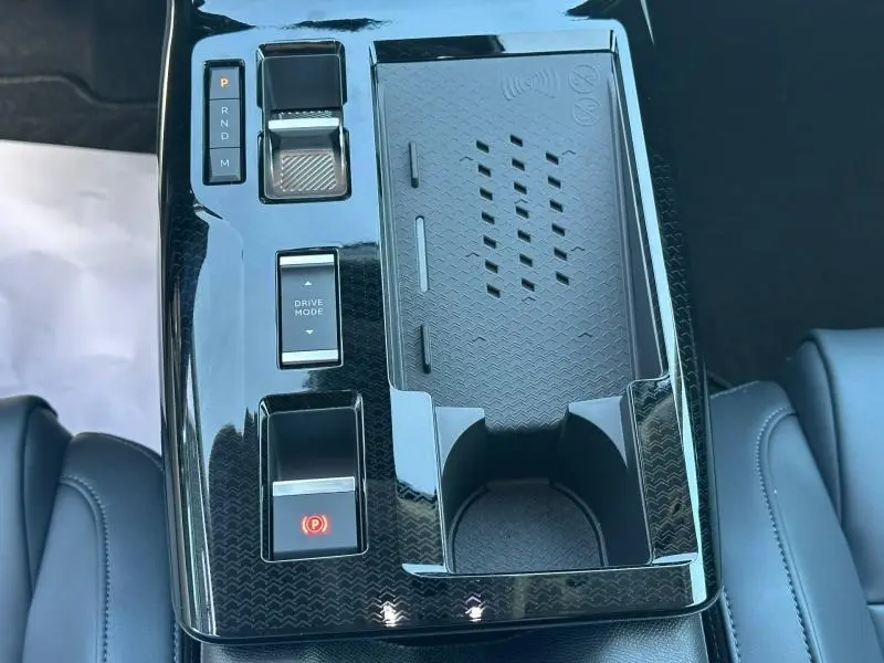 Vue plongeante sur la console centrale noire brillante du Citroën C5 Aircross gris Platinium avec commandes de boîte auto et rangement.