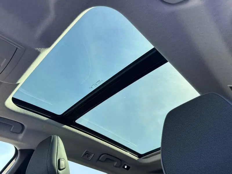 Vue intérieure du toit ouvrant panoramique du Citroën C5 Aircross gris Platinium avec ciel bleu visible à travers le verre.