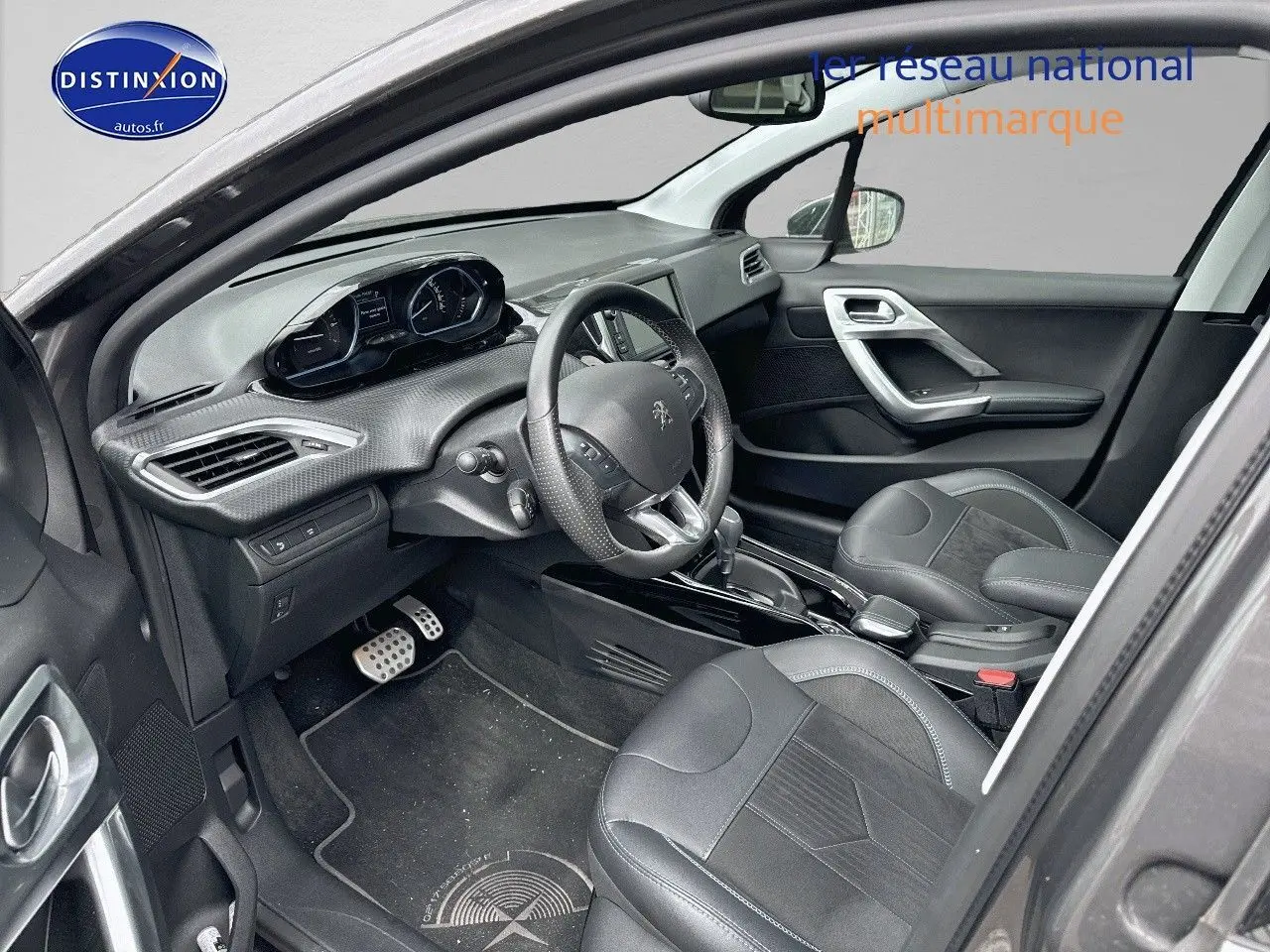 Intérieur de la Peugeot 2008 2019 en gris platinium, vue côté conducteur montrant tableau de bord et sièges cuir noirs.