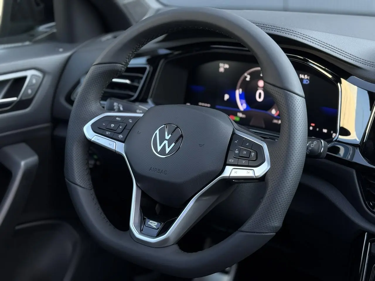 Volant sport multifonction R-Line en cuir noir avec tableau de bord digital du Volkswagen T-Roc 2025.