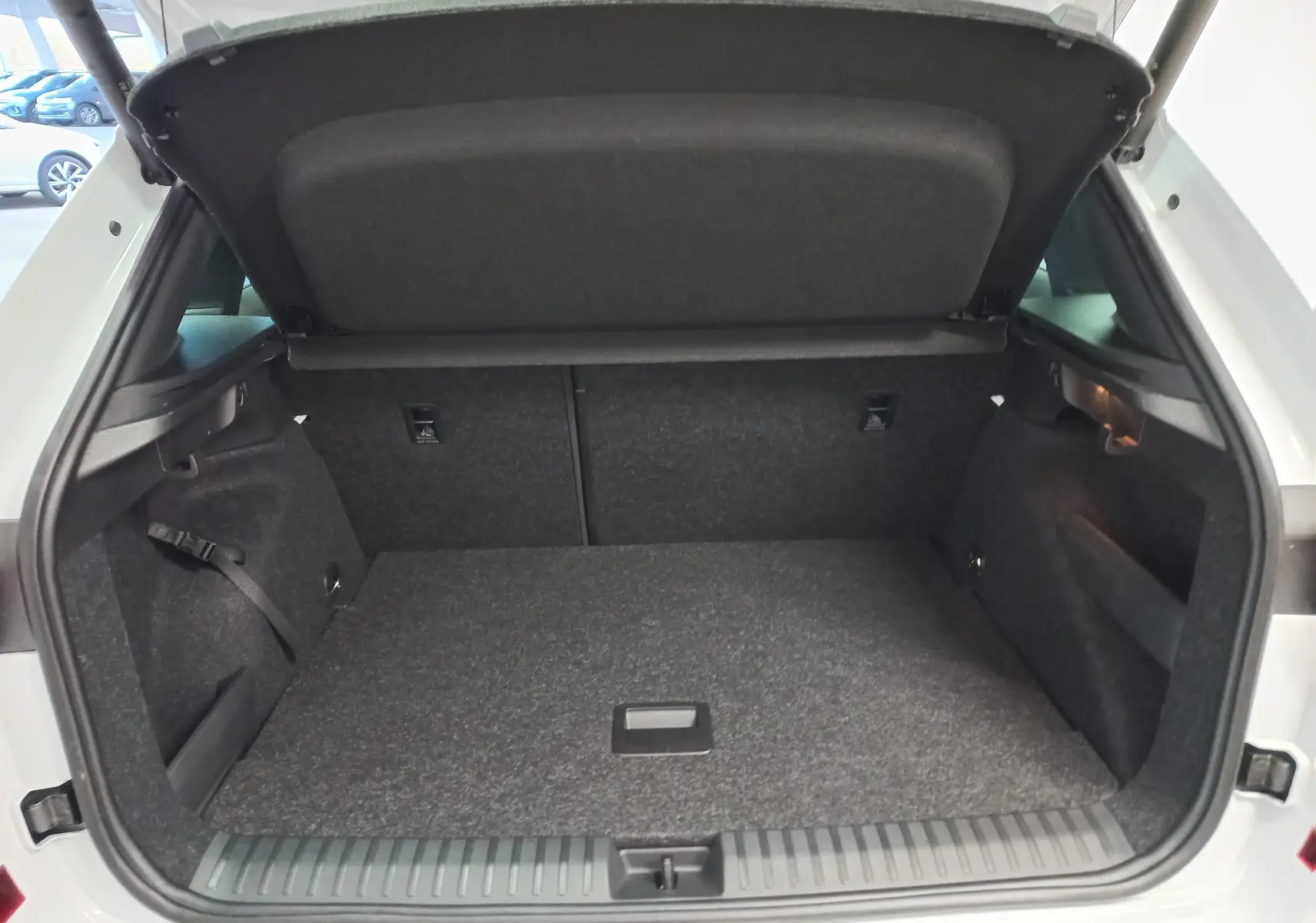 Coffre ouvert du Skoda Kamiq blanc Lune 2025, vue arrière montrant le double plancher et l'espace de rangement.