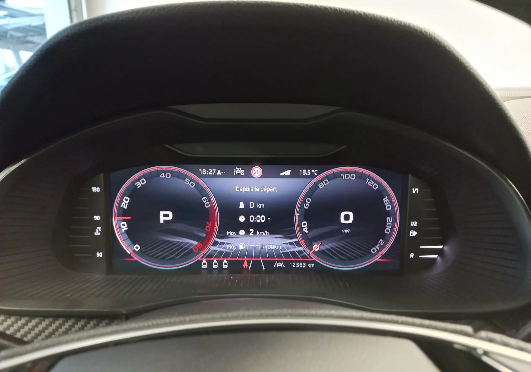 Tableau de bord numérique du Skoda Kamiq 1.5 TSI blanc, affichant vitesse à 0 km/h et mode parking actif.