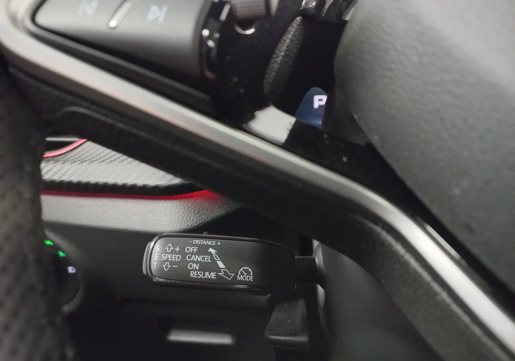 Gros plan sur la commande de régulateur de vitesse à gauche du volant du Skoda Kamiq blanc Lune 2025.