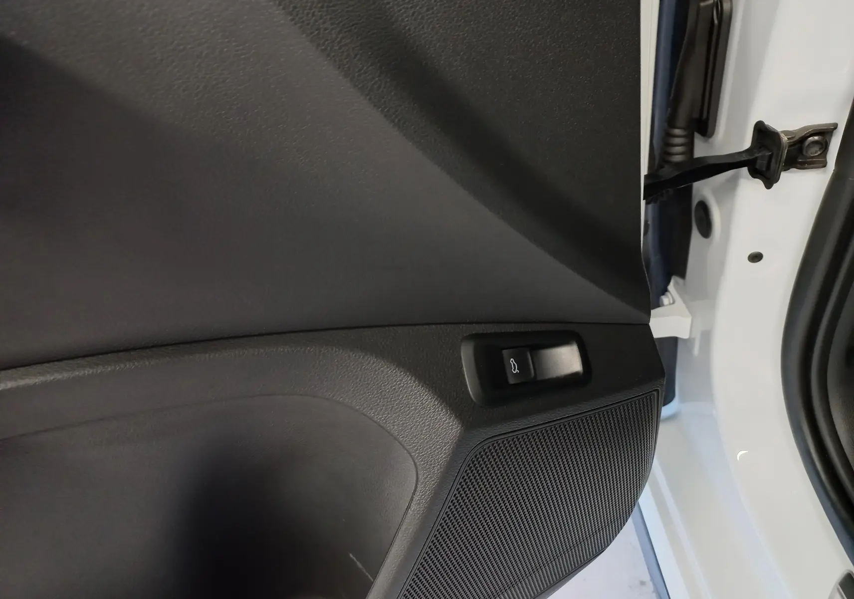Détail de la portière côté gauche du Skoda Kamiq blanc Lune avec bouton d'ouverture du coffre intégré.