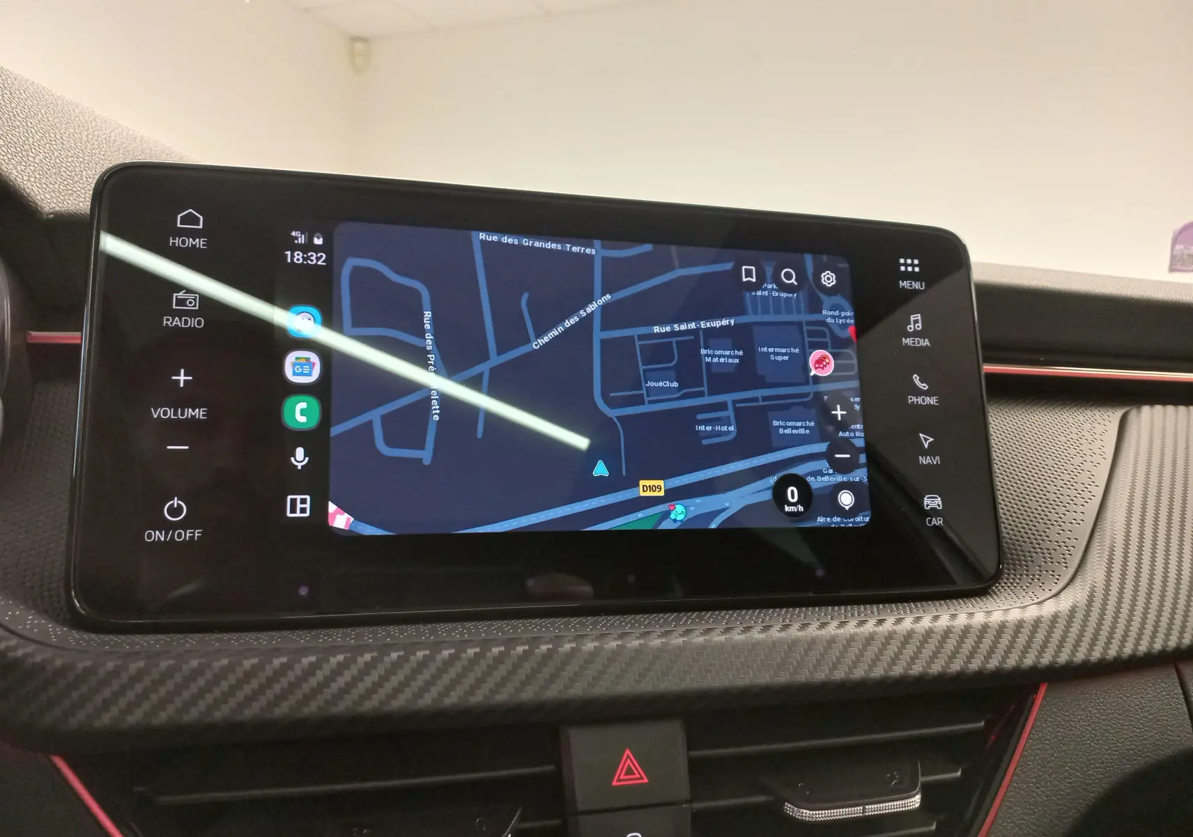 Écran tactile central du Skoda Kamiq 2025 montrant la navigation, avec finition carbone et touches tactiles latérales.