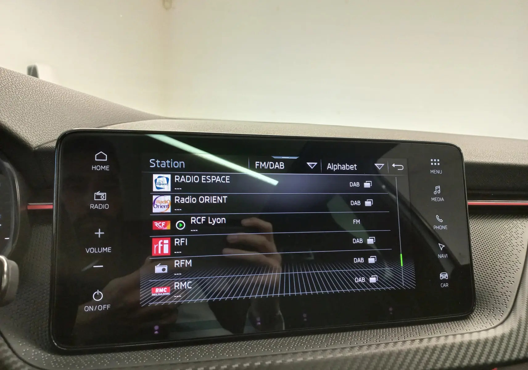 Écran tactile central du tableau de bord du Skoda Kamiq 2025 affichant la liste des stations radio FM/DAB.
