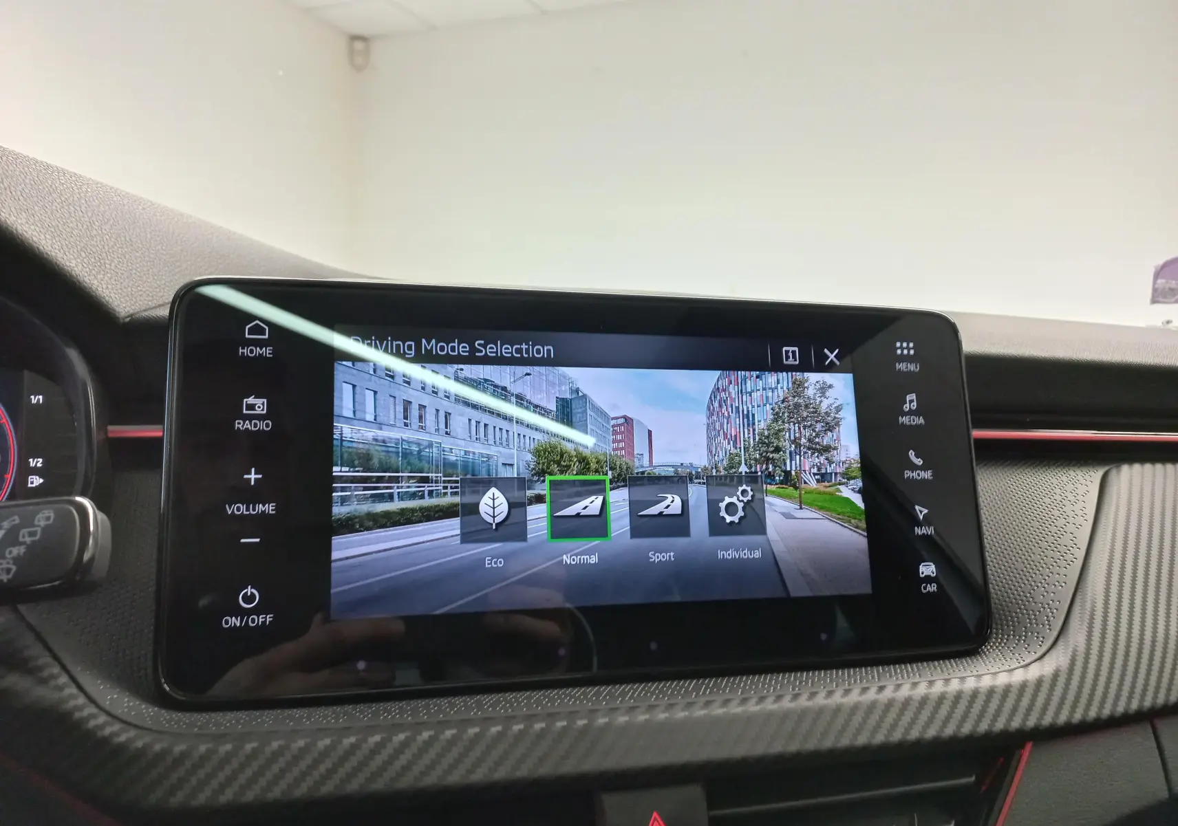 Écran tactile central affichant la sélection du mode de conduite dans un Skoda Kamiq blanc, intérieur avec finition carbone.
