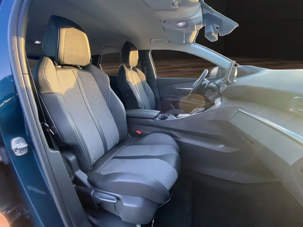 Vue intérieure côté gauche du Peugeot 3008 Bleu Celebes, mettant en valeur les sièges en tissu et cuir gris noir.