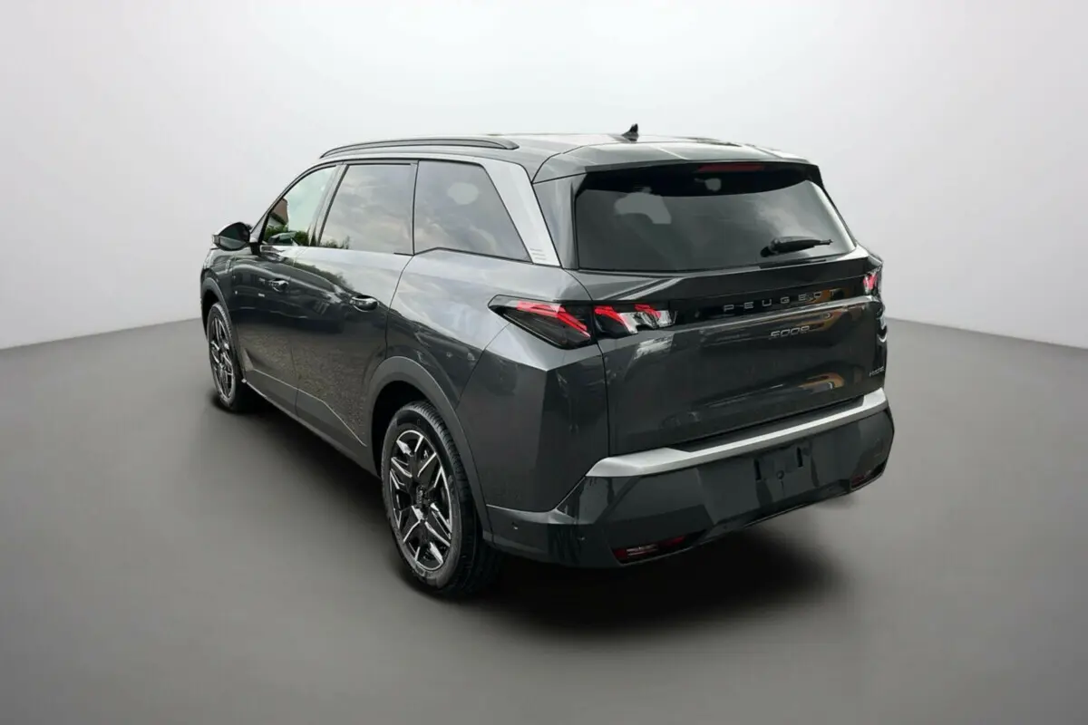 Peugeot 5008 Hybrid gris titane avec toit noir, vue 3/4 arrière droit, jantes alu 19 pouces et feux LED distinctifs.