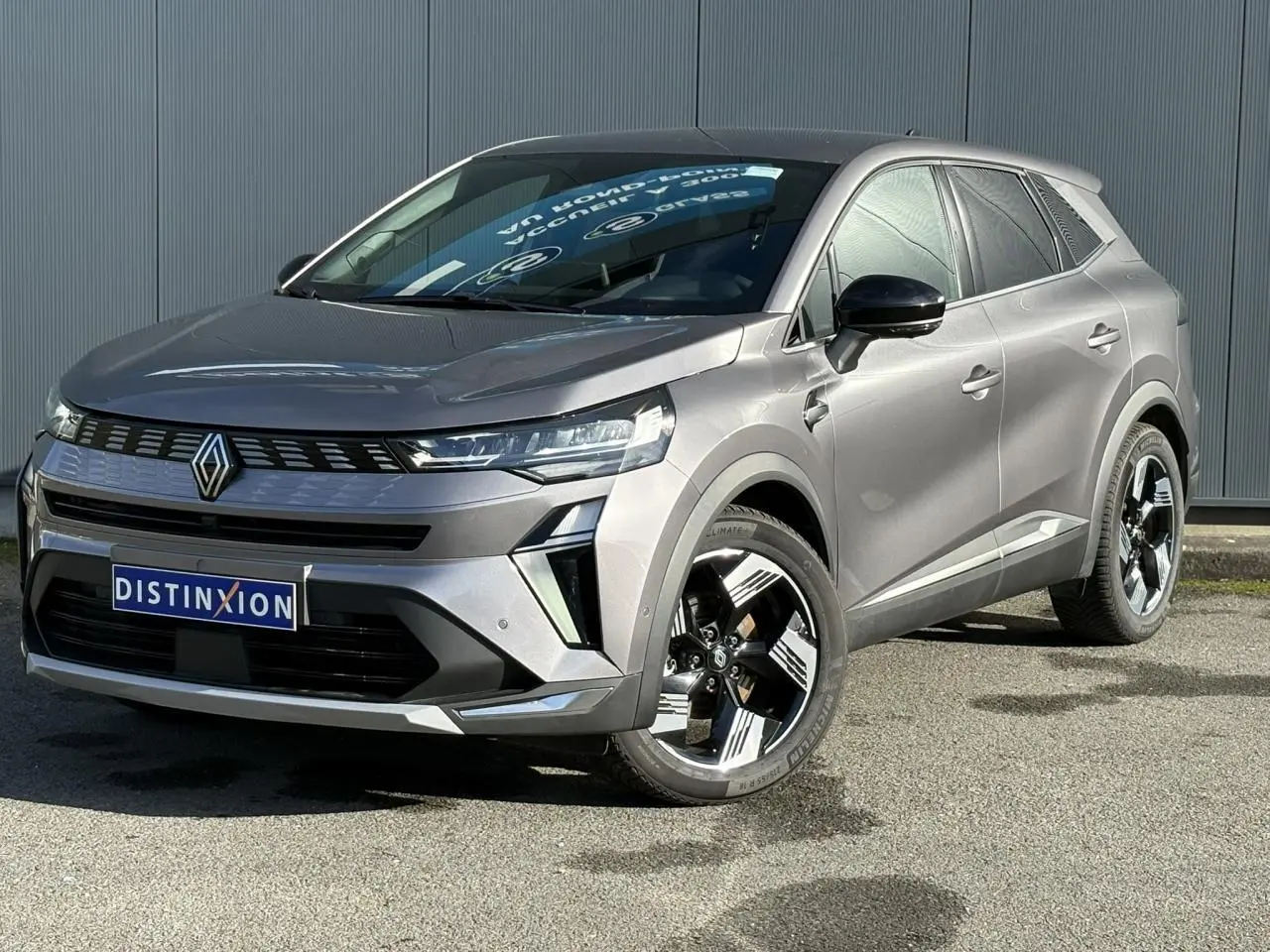 Renault Symbioz gris Cassiopée en 3/4 avant droit, avec jantes 18 pouces et calandre moderne distinctive.