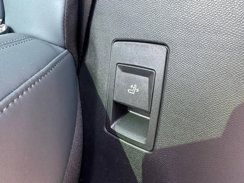Détail du bouton de rabattement de siège arrière sur la garniture intérieure noire du Citroën C5 Aircross gris Platinium.