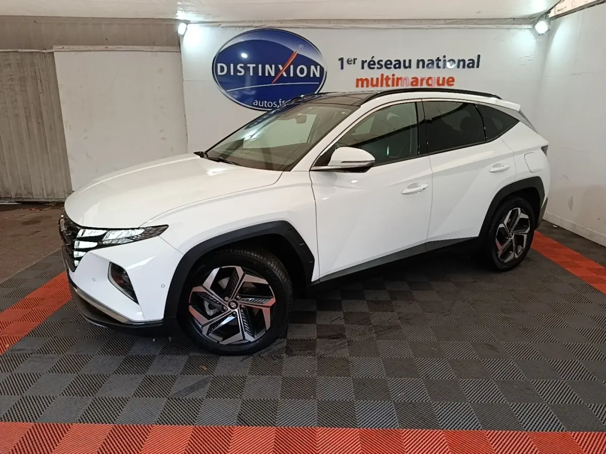 Hyundai Tucson 1.6 Hybrid 230 Executive blanc vu de profil droit en intérieur avec jantes distinctives et toit noir.