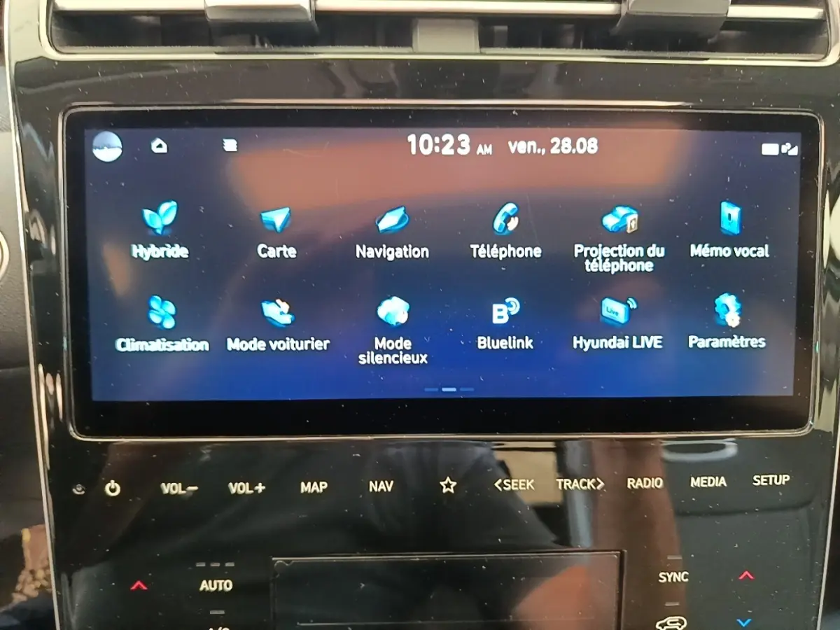Écran tactile central du Hyundai Tucson blanc 2022 affichant le menu principal des fonctions connectées.