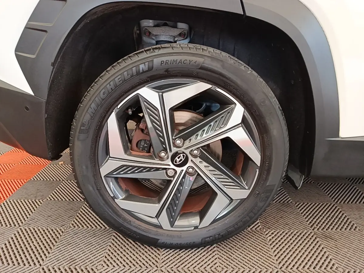 Gros plan sur la roue avant droite d’un Hyundai Tucson blanc, avec jante alliage moderne et pneu Michelin.