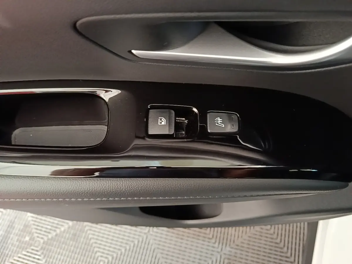 Détail intérieur montrant les commandes de lève-vitre et siège chauffant sur la porte côté conducteur d’un Hyundai Tucson blanc.