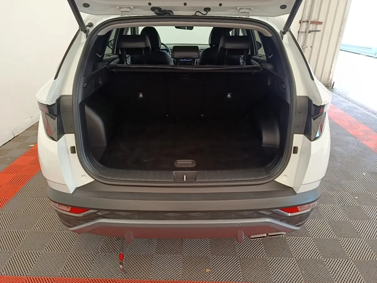 Vue arrière du Hyundai Tucson blanc 2022 avec coffre ouvert et intérieur noir visible.