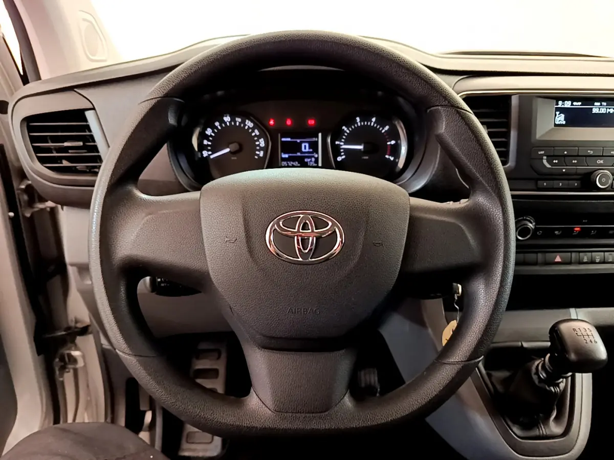 Vue intérieure centrée sur le volant noir de la Toyota Proace Verso 2019 avec tableau de bord et levier de vitesses manuel.