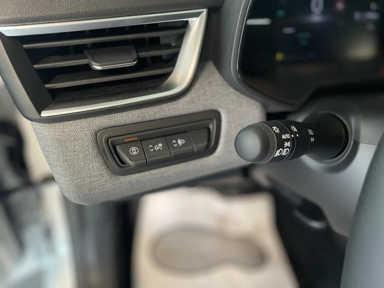 Détail intérieur côté gauche de la planche de bord de la Renault Clio 2025 avec commandes et aérateur chrome satiné.