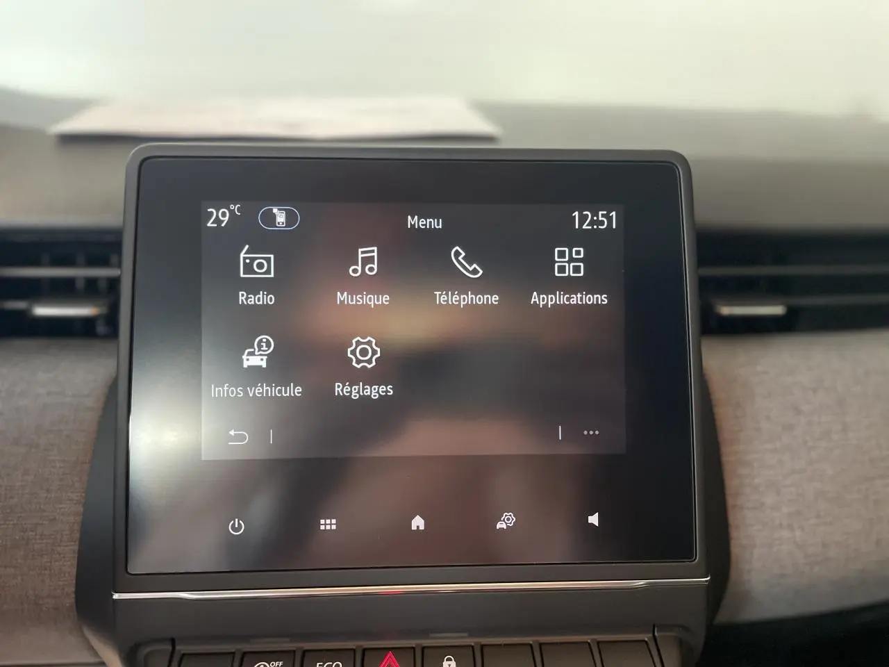 Écran tactile central de la Renault Clio blanche 2025 affichant le menu multimédia avec radio et téléphone.