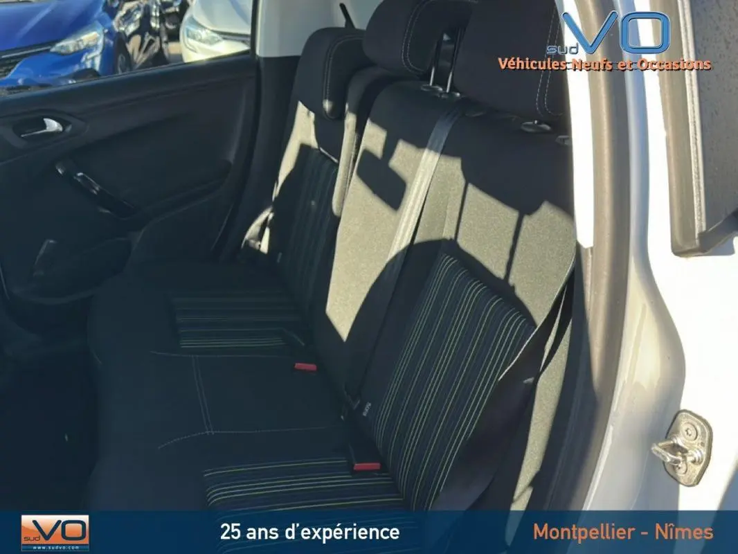 Vue intérieure côté droit des sièges arrière noirs à rayures vertes d'une Peugeot 208 blanche de 2015.