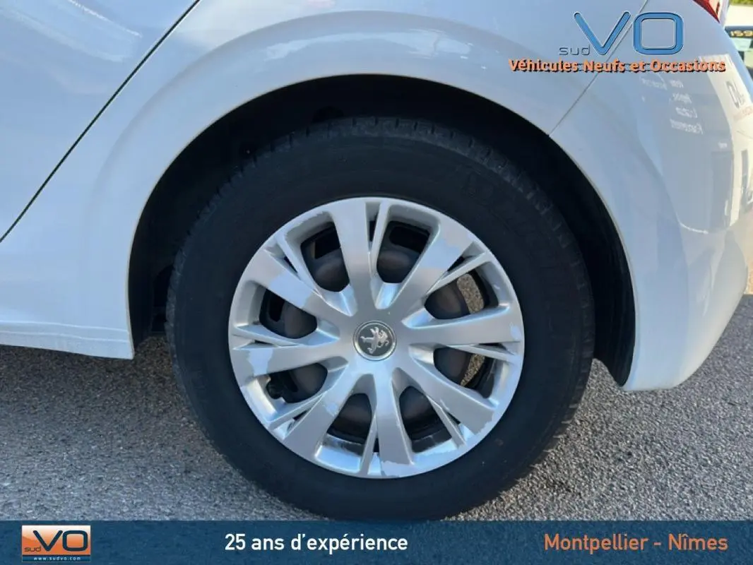 Gros plan sur la roue arrière droite blanche d'une Peugeot 208 1.2 PureTech 2015 avec jante classique 15 pouces.