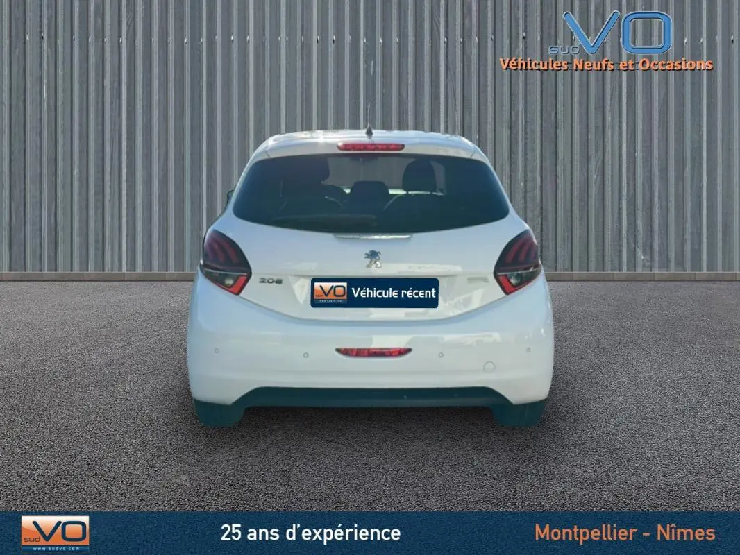 Vue arrière d'une Peugeot 208 blanche de 2015, avec feux arrière foncés et plaque "Véhicule récent" visible.
