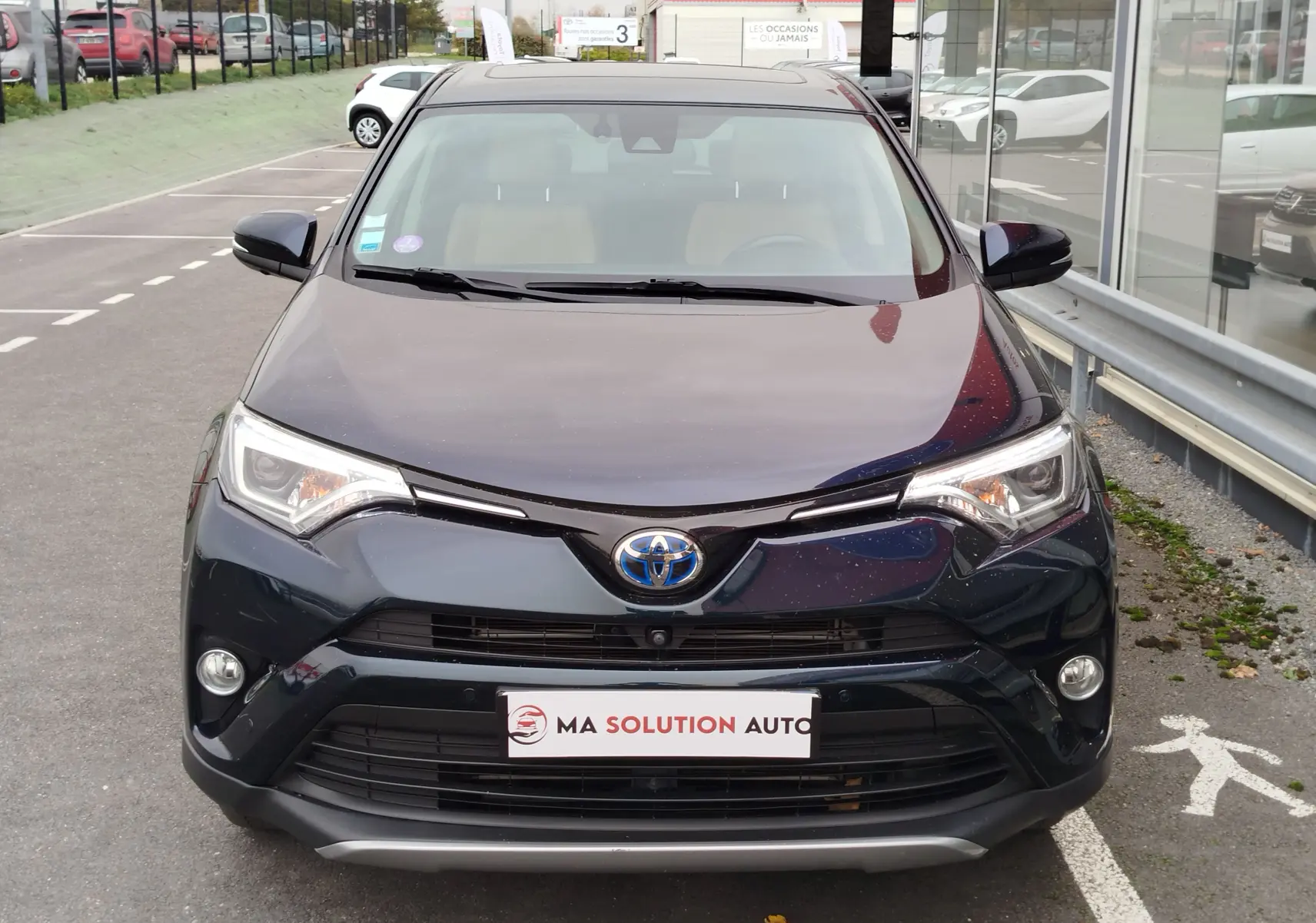 Vue frontale d'un Toyota RAV4 2017 noir cobalt, mettant en valeur ses phares LED et sa calandre distinctive.