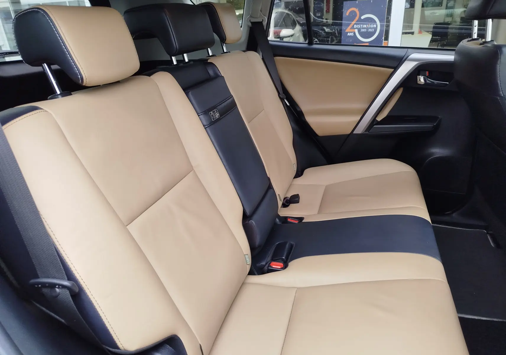 Vue latérale droite des sièges arrière en cuir beige et noir du Toyota RAV4 2017 Hybride Lounge AWD.