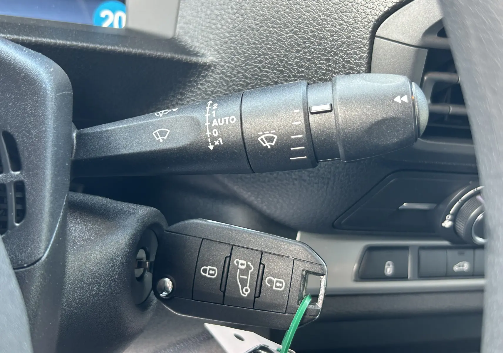 Gros plan intérieur sur la clé insérée dans le contacteur d’un Citroën Jumpy blanc, avec commandes de phares et tableau de bord partiellement visibles.