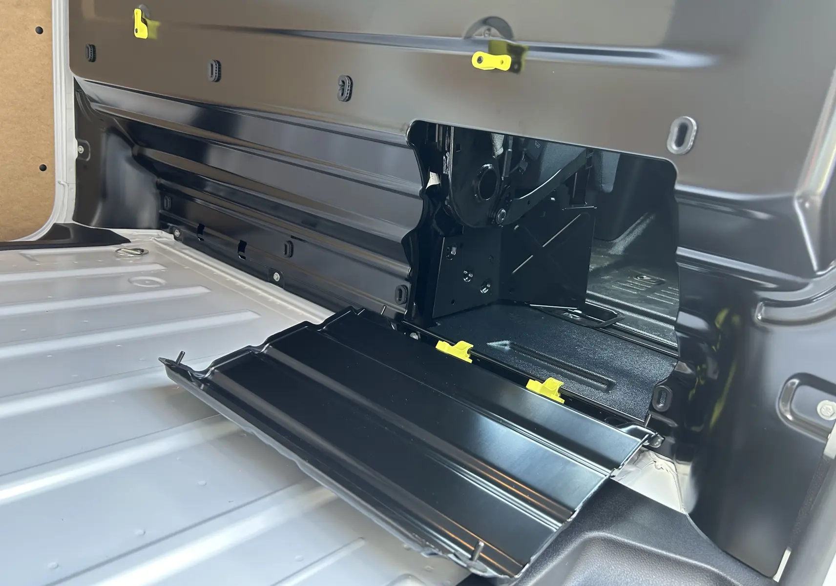Détail intérieur du plancher et cloison de chargement noir ouvert du fourgon blanc Citroën Jumpy 2025, vue rapprochée côté gauche.