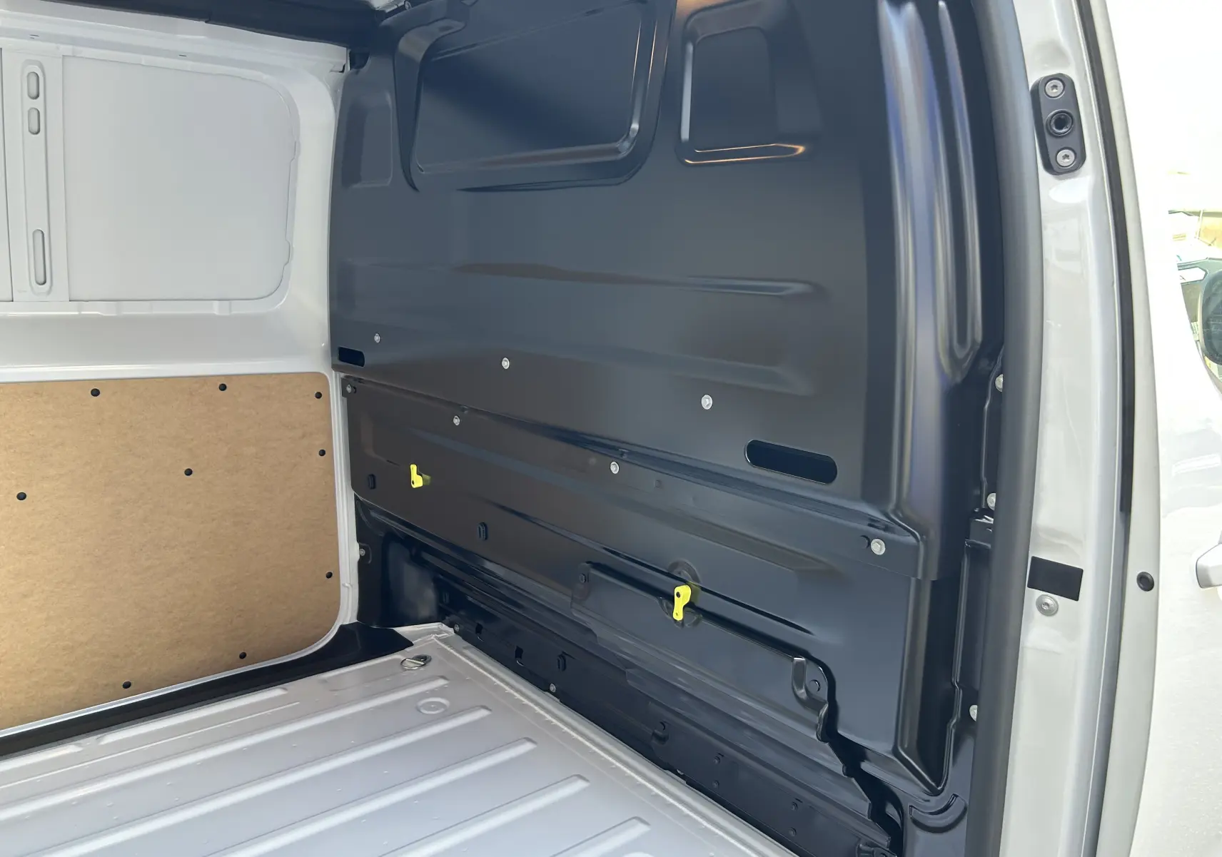 Vue intérieure arrière droite du fourgon blanc Citroën Jumpy 2025, montrant la cloison métallique et le plancher de chargement.