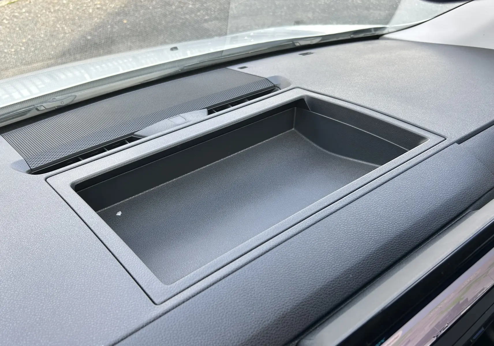 Vue rapprochée du rangement intégré au tableau de bord noir du Citroën Jumpy Fourgon blanc, intérieur avant.