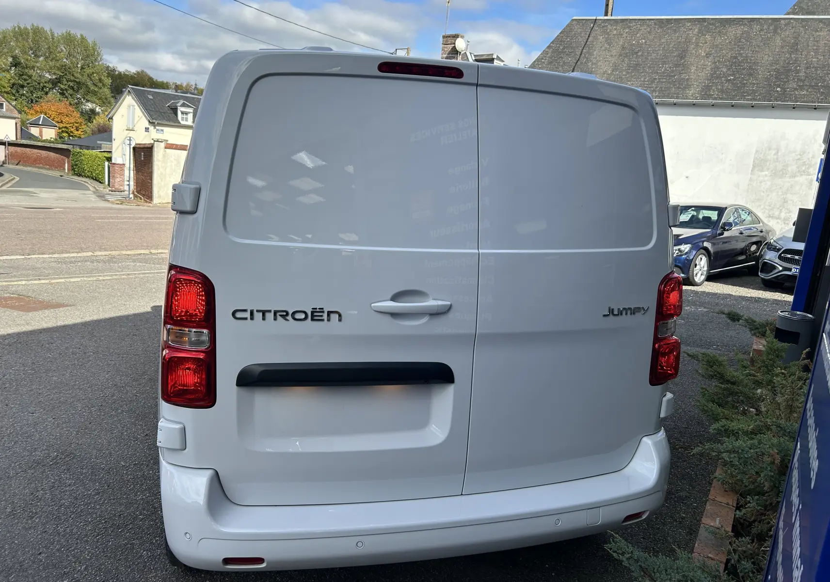 Vue arrière d’un Citroën Jumpy blanc 2025 avec portes battantes et feux rouges verticaux visibles.