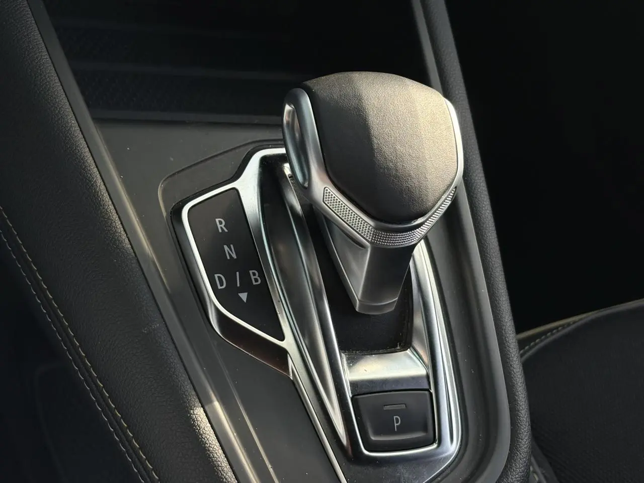 Gros plan sur le levier de vitesses automatique noir et chrome de la Renault SYMBIOZ E-Tech Full Hybrid 2025.
